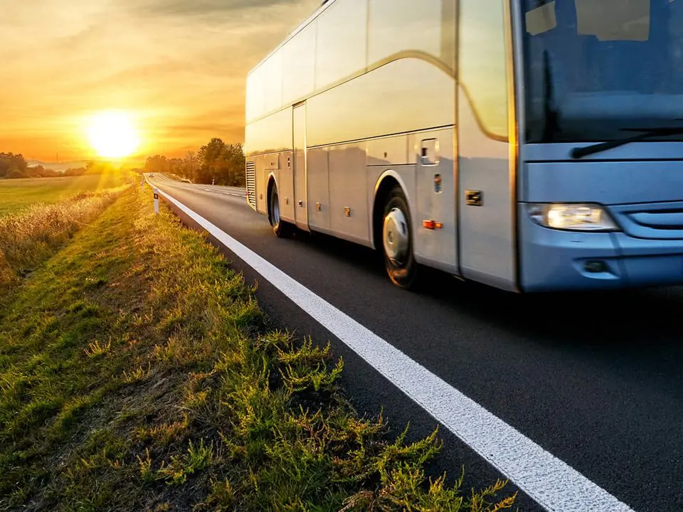 Ônibus rodoviário em estrada ao pôr do sol